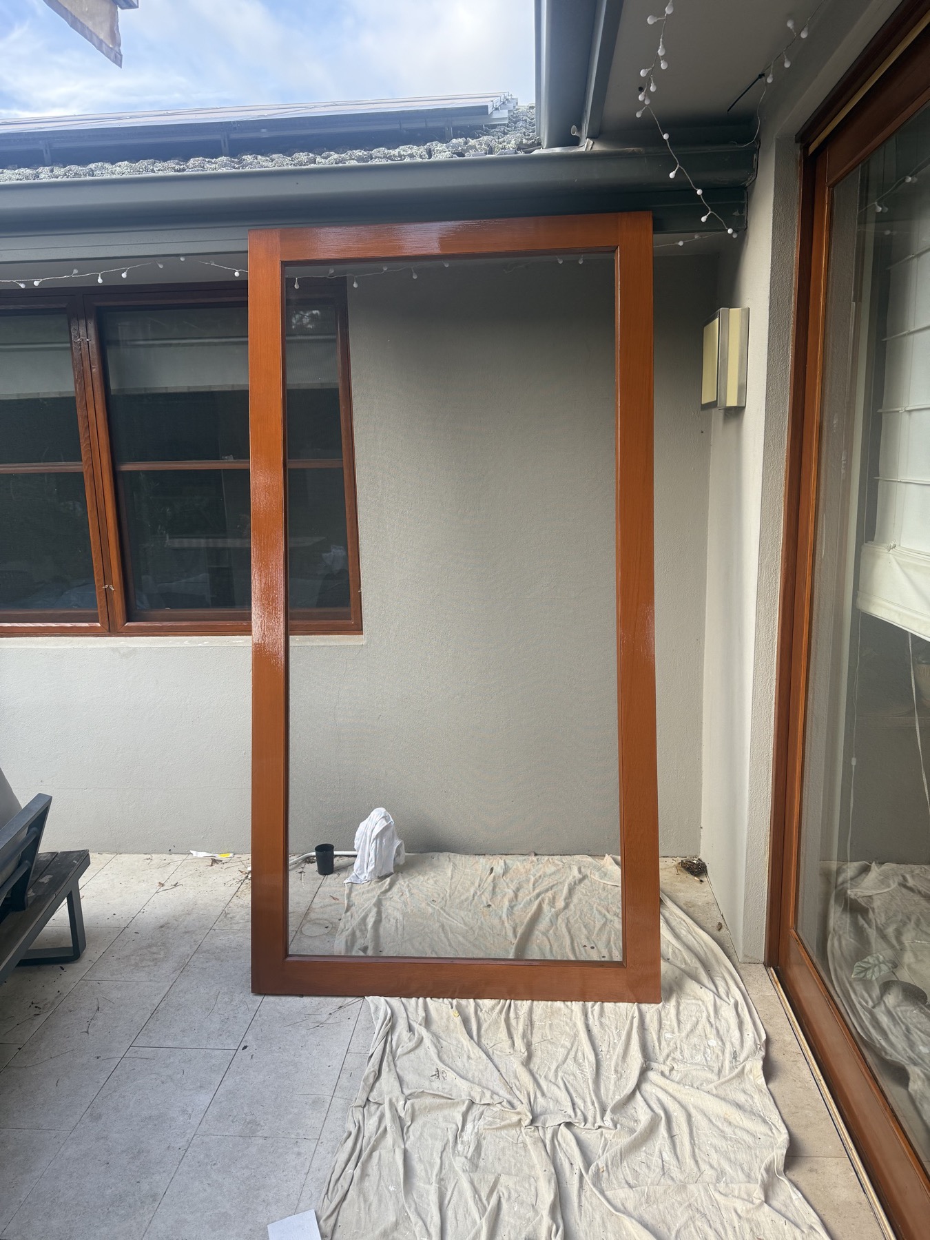 A timber door freshly finished and left to dry on a drop sheet during a Canberra painting job