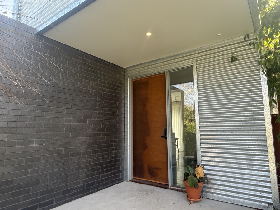 Entry door acid-etched to bring up the finish, with dark brick surround