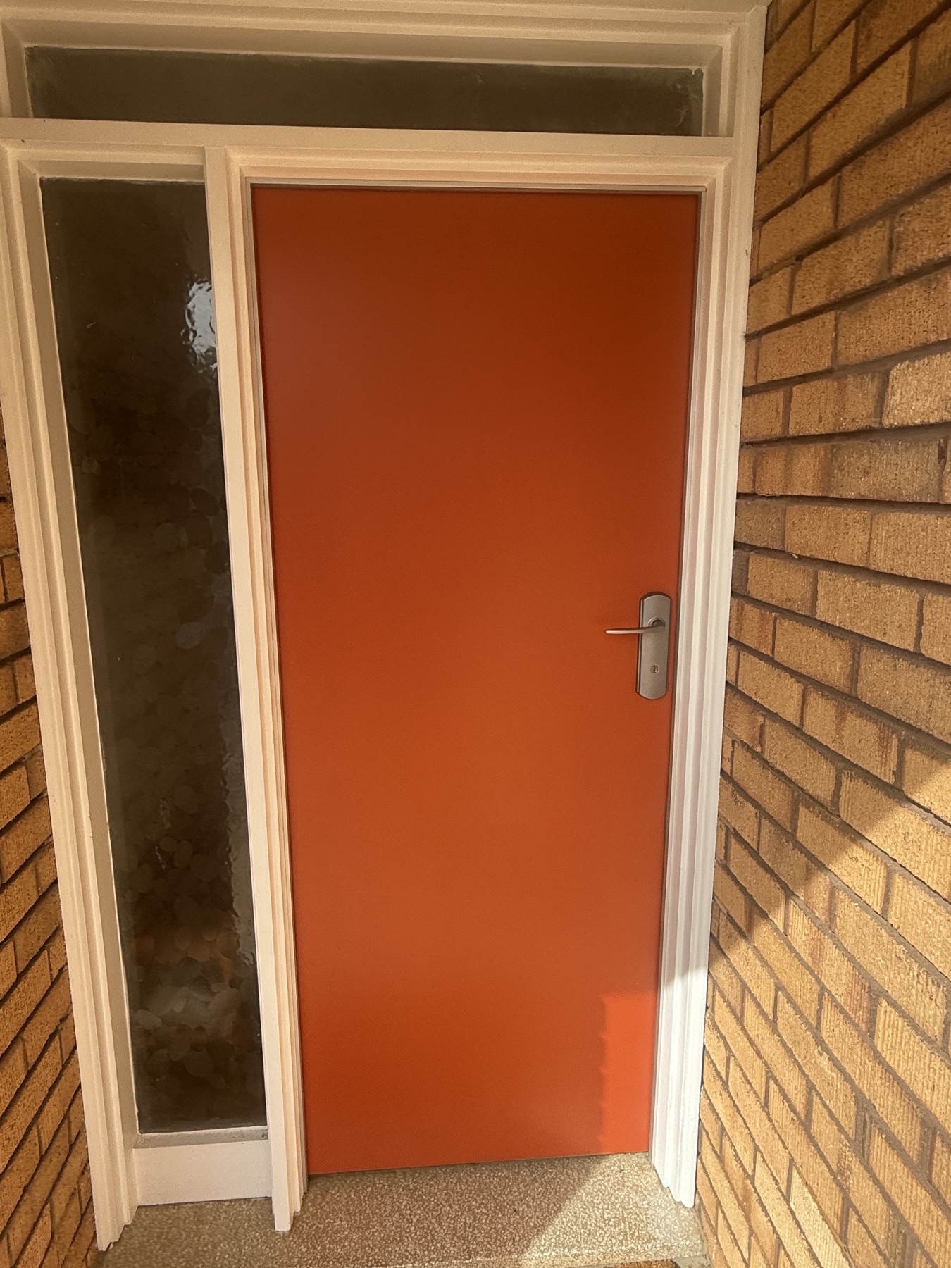 A freshly painted door and frame against the original brickwork of a Canberra home